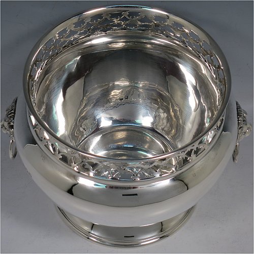 An Antique Victorian Sterling Silver table bowl, having a plain round bellied body with a hand-pierced top gallery border, together with two cast lion-mask and ring side-handles, and sitting on a plain round pedestal foot. Made by Gibson & Langland of London in 1899. The dimensions of this fine hand-made antique silver table bowl are diameter 18 cms (7 inches), height 14 cms (5.5 inches), and it weighs approx. 581g (18.7 troy ounces).    