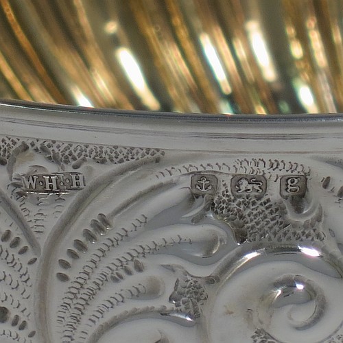 A very pretty Antique Edwardian Sterling Silver bowl, having a round body with hand-chased floral, scroll, and fluted decoration, an applied reeded border and a gold gilt interior, and all sitting on a pedestal foot with matching decoration. Made by William Hutton of Birmingham in 1906. The dimensions of this fine hand-made antique silver bowl are diameter 15 cms (6 inches), height 12 cms (4.75 inches), and it weighs approx. 247g (8 troy ounces). 