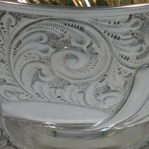 A very pretty Antique Edwardian Sterling Silver bowl, having a round body with hand-chased floral, scroll, and fluted decoration, an applied reeded border and a gold gilt interior, and all sitting on a pedestal foot with matching decoration. Made by William Hutton of Birmingham in 1906. The dimensions of this fine hand-made antique silver bowl are diameter 15 cms (6 inches), height 12 cms (4.75 inches), and it weighs approx. 247g (8 troy ounces). 