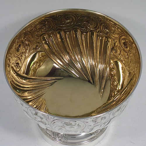 A very pretty Antique Edwardian Sterling Silver bowl, having a round body with hand-chased floral, scroll, and fluted decoration, an applied reeded border and a gold gilt interior, and all sitting on a pedestal foot with matching decoration. Made by William Hutton of Birmingham in 1906. The dimensions of this fine hand-made antique silver bowl are diameter 15 cms (6 inches), height 12 cms (4.75 inches), and it weighs approx. 247g (8 troy ounces). 