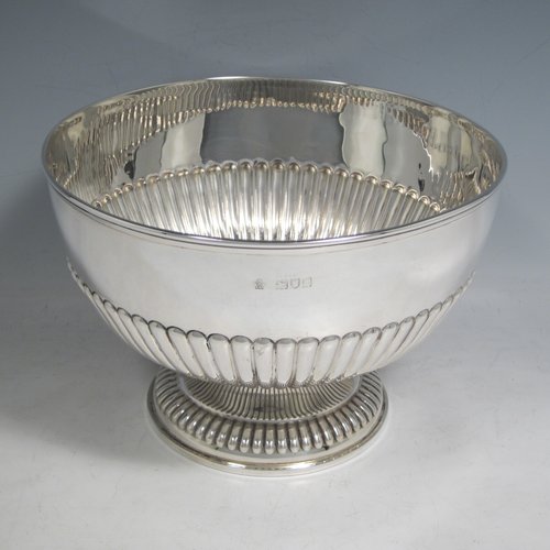 Antique Victorian sterling silver bowl, having a round hand-chased body with half-fluted decoration, an applied reeded border, and sitting on a matching pedestal foot. Made by William Hutton and Sons of London in 1898. The dimenions of this fine hand-made silver bowl are height 14 cms (5.5 inches), diameter 21 cms (8.25 inches), and it weighs approx. 525g (17 troy ounces).   