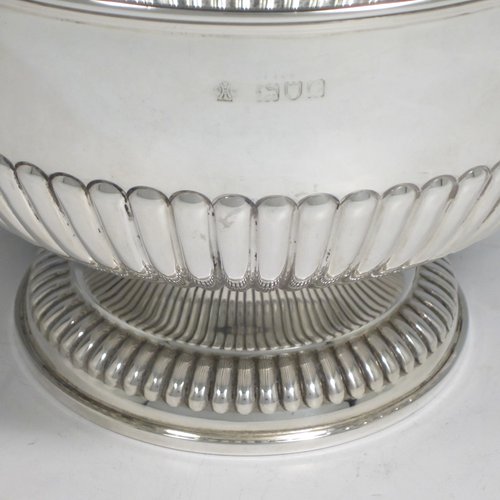 Antique Victorian sterling silver bowl, having a round hand-chased body with half-fluted decoration, an applied reeded border, and sitting on a matching pedestal foot. Made by William Hutton and Sons of London in 1898. The dimenions of this fine hand-made silver bowl are height 14 cms (5.5 inches), diameter 21 cms (8.25 inches), and it weighs approx. 525g (17 troy ounces).   