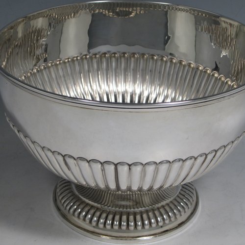 Antique Victorian sterling silver bowl, having a round hand-chased body with half-fluted decoration, an applied reeded border, and sitting on a matching pedestal foot. Made by William Hutton and Sons of London in 1898. The dimenions of this fine hand-made silver bowl are height 14 cms (5.5 inches), diameter 21 cms (8.25 inches), and it weighs approx. 525g (17 troy ounces).   