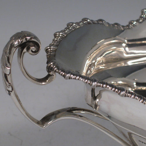 Antique Edwardian sterling silver two-handled oval bowl with gadroon edge and sitting on a pedestal foot. Made by James Dixon & Sons of Sheffield in 1905. The dimensions of this fine silver bowl are height 14 cms (5.5 inches), length 25.5 cms (10 inches), width 14 cms (5.5 inches), and it weighs approx. 13 troy ounces (403g).