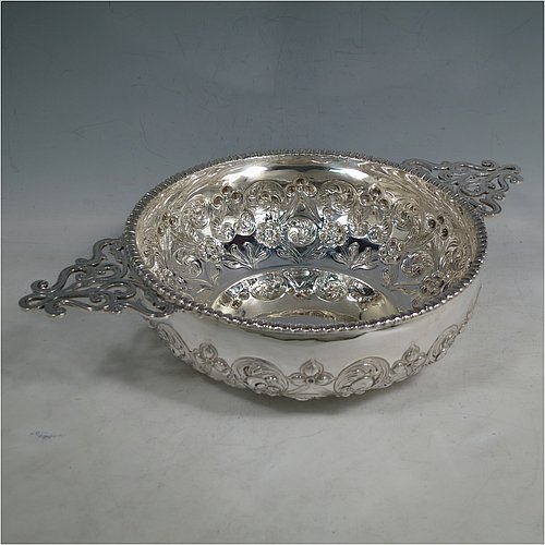 An Antique Edwardian Sterling Silver quaich style rose bowl, having a round bellied body with hand-chased floral decoration. an applied straight gadroon border, with two hand-pierced side-handles, and sitting on a flat base. Made by Peter Henderson Deere of London in 1909. The dimensions of this fine hand-made antique silver rose bowl in a quaich form are height 7 cms (2.75 inches), diameter 21.5 cms (8.5 inches), and it weighs approx. 669g (21.6 troy ounces).    