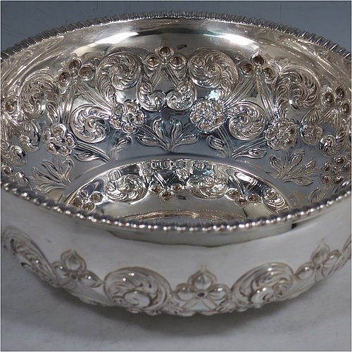 An Antique Edwardian Sterling Silver quaich style rose bowl, having a round bellied body with hand-chased floral decoration. an applied straight gadroon border, with two hand-pierced side-handles, and sitting on a flat base. Made by Peter Henderson Deere of London in 1909. The dimensions of this fine hand-made antique silver rose bowl in a quaich form are height 7 cms (2.75 inches), diameter 21.5 cms (8.5 inches), and it weighs approx. 669g (21.6 troy ounces).    