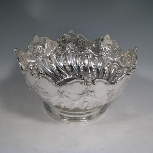 An Antique Victorian Sterling Silver Monteith style bowl, having a round body with an applied border and cast cherub heads, hand-chased floral and half swirl-fluted decoration, and sitting on a pedestal foot. Made in London in 1891. The dimensions of this fine hand-made antique silver Montieth bowl are diameter 24 cms (9.5 inches), height 14 cms (5.5 inches), and it weighs approx. 882g (28.5 troy ounces).   