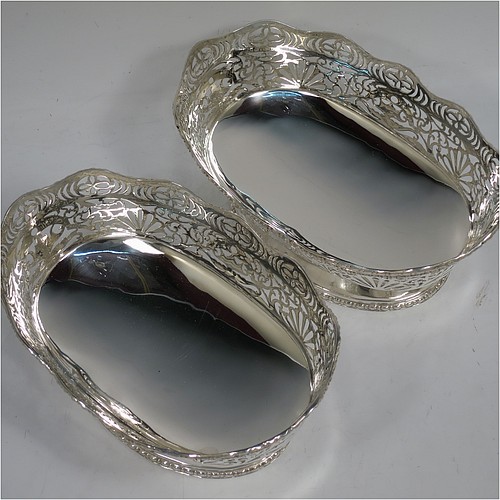 A very pretty pair of Sterling Silver table bowls, having oval bodies with hand-pierced floral and scroll decoration, with applied wavy bead-edged borders, and all sitting on pedestal feet. Made by S. Blanckensee and Sons Ltd., of Chester in 1930. The dimensions of these fine hand-made oval silver bowls are length 19 cms (7.5 inches), width 12.5 cms (5 inches), height 8 cms (3.25 inches), and they weigh a total of approx. 566g (18 troy ounces).   