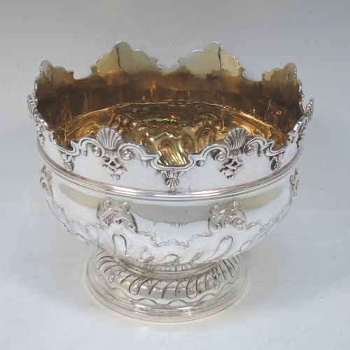 A very pretty Antique Victorian Sterling Silver Montieth style rose bowl, having a round body with hand-chased swirl half-fluting and a gold-gilt interior, below an applied reeded band, an applied shell and scroll border, and all sitting on a pedestal foot. Made by Charles Stuart Harris of London in 1900. The dimensions of this fine hand-made antique silver rose Montieth bowl are height 15 cms (6 inches), diameter 19 cms (7.5 inches), and it weighs approx. 740g (23.9 troy ounces).  