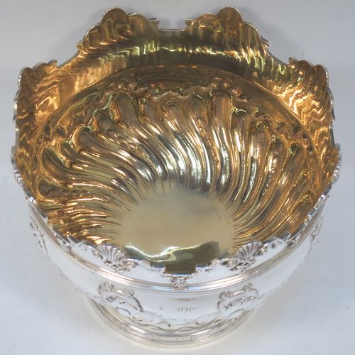 A very pretty Antique Victorian Sterling Silver Montieth style rose bowl, having a round body with hand-chased swirl half-fluting and a gold-gilt interior, below an applied reeded band, an applied shell and scroll border, and all sitting on a pedestal foot. Made by Charles Stuart Harris of London in 1900. The dimensions of this fine hand-made antique silver rose Montieth bowl are height 15 cms (6 inches), diameter 19 cms (7.5 inches), and it weighs approx. 740g (23.9 troy ounces).  