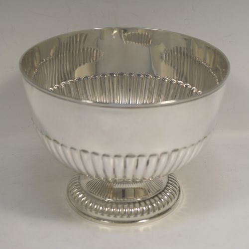 A very handsome Antique Edwardian Sterling Silver Rose bowl, having a round body with hand-chased half-fluted decoration, and sitting on a pedestal foot. This elegant antique silver rose bowl was made by William Hutton of London in 1906. The dimensions of this fine hand-made silver bowl are height 14 cms (5.5 inches), diameter 18 cms (7 inches), and it weighs approx. 464g (15 troy ounces).   