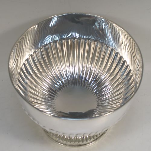 A very handsome Antique Edwardian Sterling Silver Rose bowl, having a round body with hand-chased half-fluted decoration, and sitting on a pedestal foot. This elegant antique silver rose bowl was made by William Hutton of London in 1906. The dimensions of this fine hand-made silver bowl are height 14 cms (5.5 inches), diameter 18 cms (7 inches), and it weighs approx. 464g (15 troy ounces).   