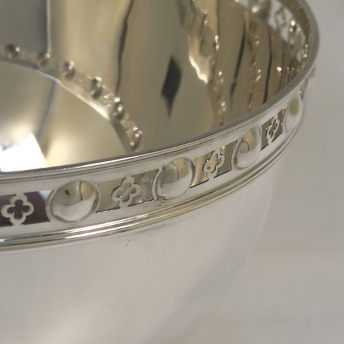 A very handsome Antique Edwardian Sterling Silver Rose bowl, having a plain round body with a pretty hand-pierced top border, and sitting on a round pedestal foot with matching decoration. This elegant antique silver rose bowl was made by Martin Hall and Co., of Sheffield in 1904. The dimensions of this fine hand-made silver bowl are height 14 cms (5.5 inches), diameter 21 cms (8.25 inches), and it weighs approx. 684g (22 troy ounces).