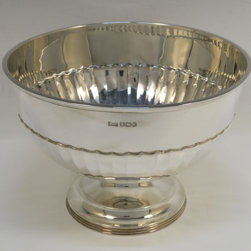 A very handsome Antique Sterling Silver Rose bowl, having a round body with hand-chased half-fluted decoration, and sitting on a pedestal foot with a reeded bottom border. This elegant silver rose bowl was made by Walker and Hall of Sheffield in 1924. The dimensions of this fine hand-made antique silver bowl are height 14 cms (5.5 inches), diameter 21 cms (8.25 inches), and it weighs approx. 518g (16.7 troy ounces).   