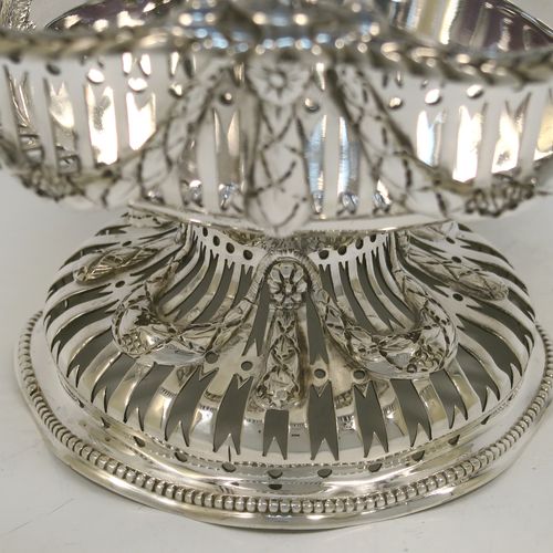 A beautiful Antique Victorian Sterling Silver bowl, having a round body with hand-pierced Neoclassical style decoration, an applied cast floral and swag border, and  sitting on a matching round pedestal foot. This pretty antique silver bowl was made by Frazer and Haws of London in 1899. The dimensions of this fine hand-made antique silver bowl are height 12 cms (4.75 inches), diameter 21 cms (8.25 inches), and it weighs approx. 527g (17 troy ounces).   