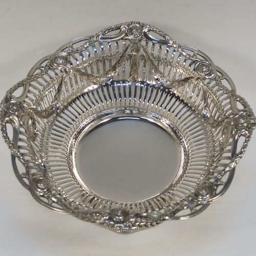 A beautiful Antique Victorian Sterling Silver bowl, having a round body with hand-pierced Neoclassical style decoration, an applied cast floral and swag border, and  sitting on a matching round pedestal foot. This pretty antique silver bowl was made by Frazer and Haws of London in 1899. The dimensions of this fine hand-made antique silver bowl are height 12 cms (4.75 inches), diameter 21 cms (8.25 inches), and it weighs approx. 527g (17 troy ounces).   