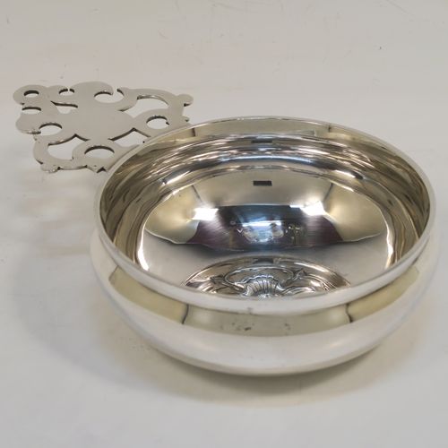 A handsome Antique Victorian Sterling Silver copy of a Georgian George I bleeding bowl, having a plain round bellied body, with a hand-pierced flat side-handle, a central hand-chased Tudor rose, and sitting on a flat base. This elegant side-handled bowl was made by Carrington and Co., of London in 1900. The dimensions of this fine hand-made silver  bowl are height 4.5 cms (1.75 inches), diameter 11.5 cms (4.5 inches), and it weighs approx. 200g (6.5 troy ounces).  