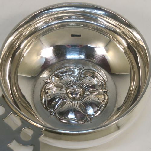 A handsome Antique Victorian Sterling Silver copy of a Georgian George I bleeding bowl, having a plain round bellied body, with a hand-pierced flat side-handle, a central hand-chased Tudor rose, and sitting on a flat base. This elegant side-handled bowl was made by Carrington and Co., of London in 1900. The dimensions of this fine hand-made silver  bowl are height 4.5 cms (1.75 inches), diameter 11.5 cms (4.5 inches), and it weighs approx. 200g (6.5 troy ounces).  