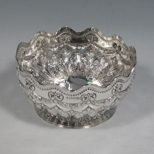 Antique Victorian sterling silver set of four bowls, having round bodies with hand-chased neoclassical style decoration showing bows, swags, and anthemion leaves, applied wavey gadroon borders, and sitting on hand-chased pedestal feet. Made by Martin and Hall of London in 1887. The dimensions of these fine hand-made silver bowls are diameter 13 cms (5 inches), height 6.5 cms (2.5 inches), and they weigh a total of 695g (22 troy ounces).