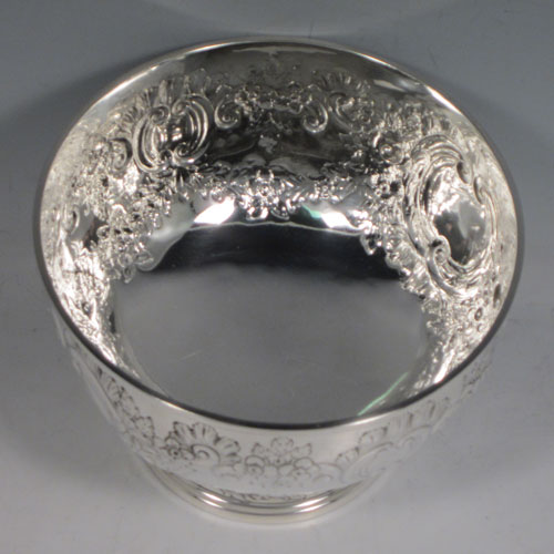 Antique Edwardian sterling silver rose bowl, having a round body with hand-chased floral decoration, two vacant cartouches, and sitting on a pedestal foot. Made by Elkington and Co., of Birmingham in 1903. The dimensions of this fine hand-made silver rose bowl are height 11 cms (4.25 inches), diameter 15 cms (6 inches), and the total weight is approx. 326g (10.5 troy ounces).