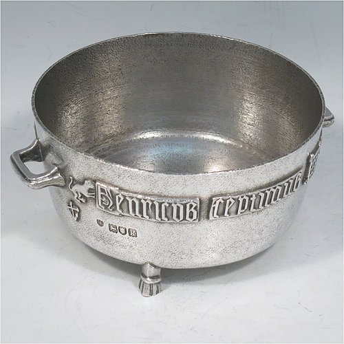 An Antique Edwardian Sterling Silver Arts & Crafts style bowl, being a copy of the Winchester Bushel measure, having a round straight-sided body with a hand-hammered finish, an applied inscription on both sides, with two cast handles, and sitting on four cast feet. Made by the Barnard Brothers of London  in 1905. The dimensions of this fine hand-made antique silver bowl are height 8 cms (2.3 inches), diameter 11.5 cms (4.5 inches), and it weighs approx. 325g (10.5 troy ounces).   