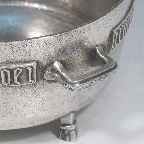 An Antique Edwardian Sterling Silver Arts & Crafts style bowl, being a copy of the Winchester Bushel measure, having a round straight-sided body with a hand-hammered finish, an applied inscription on both sides, with two cast handles, and sitting on four cast feet. Made by the Barnard Brothers of London  in 1905. The dimensions of this fine hand-made antique silver bowl are height 8 cms (2.3 inches), diameter 11.5 cms (4.5 inches), and it weighs approx. 325g (10.5 troy ounces).   