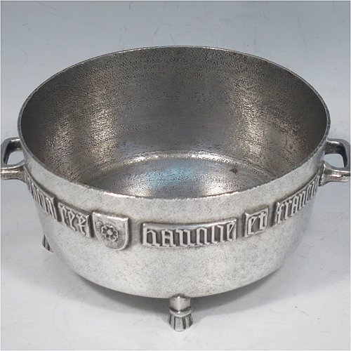 An Antique Edwardian Sterling Silver Arts & Crafts style bowl, being a copy of the Winchester Bushel measure, having a round straight-sided body with a hand-hammered finish, an applied inscription on both sides, with two cast handles, and sitting on four cast feet. Made by the Barnard Brothers of London  in 1905. The dimensions of this fine hand-made antique silver bowl are height 8 cms (2.3 inches), diameter 11.5 cms (4.5 inches), and it weighs approx. 325g (10.5 troy ounces).   