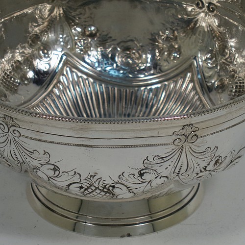 A very pretty Antique Victorian Sterling Silver bowl, having a round body with hand-chased swags of floral and scroll decoration over a lower band of vertical fluting, with an applied bead-edged border, and all sitting on a collet foot. Made by Edward Hutton of London in 1885. The dimensions of this fine hand-made antique silver bowl are diameter 11 cms (4.3 inches), height 6 cms (2.3 inches), and it weighs approx. 140g (4.5 troy ounces).    