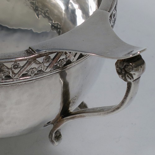 A very unusual and pretty pair of Arts and Crafts style Sterling Silver bowls, having oval bodies with hand-hammered decoration, with hand-pierced and floral borders, two scroll side-handles with flat thumb-pieces, and all sitting on four cast goat hoof feet. Made by A. E. Jones of Birmingham in 1921. The dimensions of these fine hand-made Arts and Crafts silver oval bowls are length 21 cms (8.25 inches), width 11 cms (4.3 inches), height 6.5 cms (2.5 inches), and they weigh a total of approx. 470g (15.2 troy ounces).    