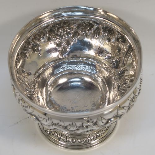 A rare and very pretty Antique Georgian George II Sterling Silver small rose bowl, having a round body with hand-chased floral decoration surrounding two cartouches on either side, and sitting on a round pedestal foot. This beautiful antique silver bowl was made by Thomas Whipham and Charles Wright of London in 1758. The dimensions of this fine hand-made antique silver rose bowl are height 9.5 cms (3.75 inches), diameter 12.5 cms (5 inches), with a weight of approx. 271g (8.7 troy ounces). Please note that one of the cartouches is engraved with a contemporaneous set of initials. 