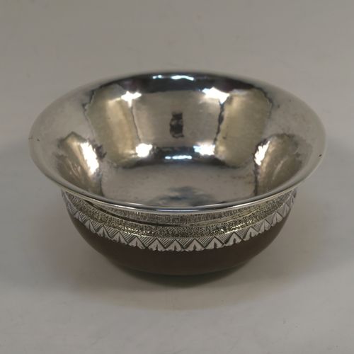 An Arts and Crafts style Sterling Silver & wood Mazer bowl, having a plain round plenished or hand-hammered body, mounted on an Oak base, and having an applied central Celtic style band. This beautiful silver Mazer bowl was made by A. E. Jones of Birmingham in 1928. The dimensions of this fine hand-made wood & silver Mazer bowl are diameter 14 cms (5.5 inches), and height 6.5 cms (2.5 inches). We cannot give a total weight because of the wooden base, but the gauge of silver used is very good.  