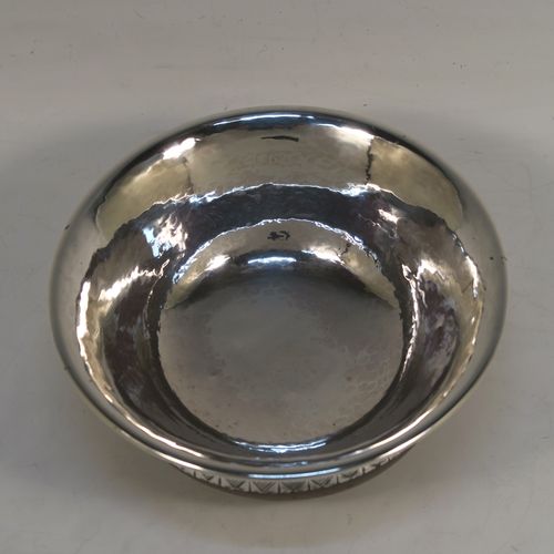 An Arts and Crafts style Sterling Silver & wood Mazer bowl, having a plain round plenished or hand-hammered body, mounted on an Oak base, and having an applied central Celtic style band. This beautiful silver Mazer bowl was made by A. E. Jones of Birmingham in 1928. The dimensions of this fine hand-made wood & silver Mazer bowl are diameter 14 cms (5.5 inches), and height 6.5 cms (2.5 inches). We cannot give a total weight because of the wooden base, but the gauge of silver used is very good.  