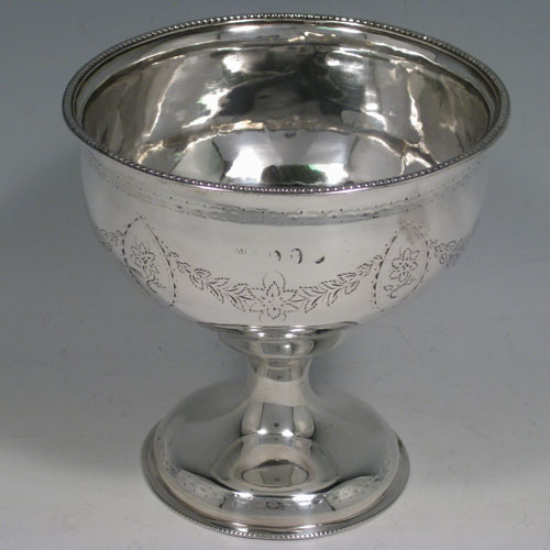 Antique Georgian sterling silver rare Irish table bowl, having a round body with engraved floral swags, sitting on a pedestal foot, and with bead edges. Made by Matthew West of Dublin in ca. 1770. Height 13 cms (5 inches), diameter at lip 23 cms (5 inches). Weight approx. 230g (7.4 troy ounces).