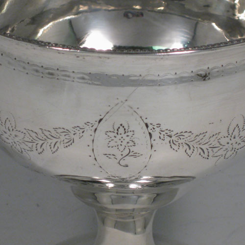 Antique Georgian sterling silver rare Irish table bowl, having a round body with engraved floral swags, sitting on a pedestal foot, and with bead edges. Made by Matthew West of Dublin in ca. 1770. Height 13 cms (5 inches), diameter at lip 23 cms (5 inches). Weight approx. 230g (7.4 troy ounces).