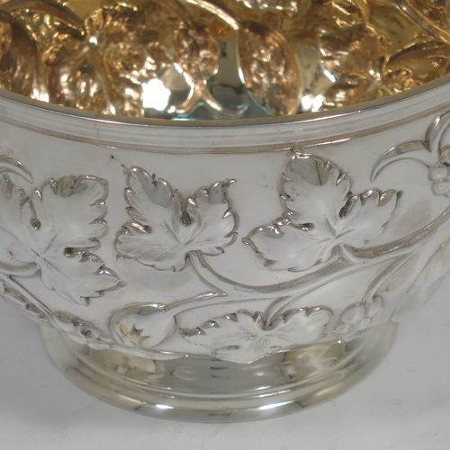 A very pretty Antique Victorian Sterling Silver rose bowl, having a round body with hand-chased fruit and floral decoration surrounding two vacant cartouches, a gold-gilt interior, and sitting on a collet foot. Made by Martin and Hall of Sheffield in in 1863. The dimensions of this fine hand-made antique silver rose bowl are height 7.5 cms (3 inches), diameter 11.5 cms (4.5 inches), with a weight of approx. 165g (5.3 troy ounces).   