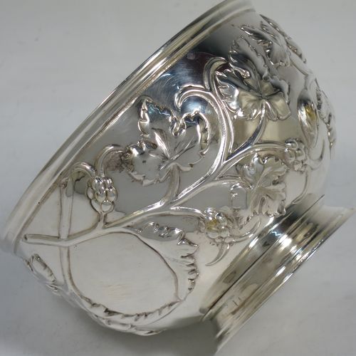 A very pretty Antique Victorian Sterling Silver rose bowl, having a round body with hand-chased fruit and floral decoration surrounding two vacant cartouches, a gold-gilt interior, and sitting on a collet foot. Made by Martin and Hall of Sheffield in in 1863. The dimensions of this fine hand-made antique silver rose bowl are height 7.5 cms (3 inches), diameter 11.5 cms (4.5 inches), with a weight of approx. 165g (5.3 troy ounces).   