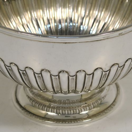 A very handsome Antique Victorian Sterling Silver small Rose bowl, having a round body with hand-chased half-fluted decoration, an applied reeded top border, and sitting on a round pedestal foot. This elegant antique silver rose bowl was made by Frederick Burridge of London in 1898. The dimensions of this fine hand-made silver bowl are height 8.5 cms (3.3 inches), diameter 13.5 cms (5.3 inches), and it weighs approx. 178g (5.7 troy ounces).   