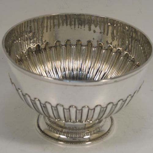 A very handsome Antique Victorian Sterling Silver small Rose bowl, having a round body with hand-chased half-fluted decoration, an applied reeded top border, and sitting on a round pedestal foot. This elegant antique silver rose bowl was made by Frederick Burridge of London in 1898. The dimensions of this fine hand-made silver bowl are height 8.5 cms (3.3 inches), diameter 13.5 cms (5.3 inches), and it weighs approx. 178g (5.7 troy ounces).   