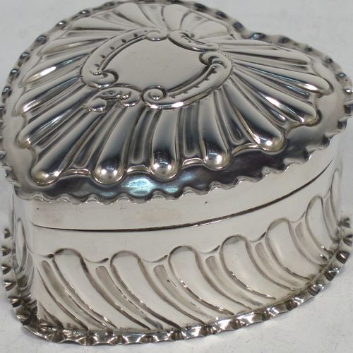 A very pretty Antique Victorian Sterling Silver heart-shaped table box, having a gold-gilt interior, all hand-chased with scroll-work, a hinged lid with vacant cartouche, and all sitting on a flat base. Made by Streeter and Co. Ltd., of London in 1899. The dimensions of this fine hand-made antique silver box are length 6 cms (2.3 inches), width 6 cms (2.3 inches), height 4 cms (1.5 inches), and it weighs approx. 49g (1.6 troy ounces).    