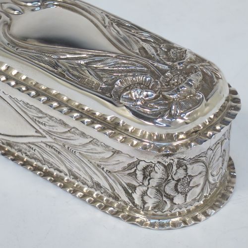 A bold and very pretty Antique Edwardian Sterling Silver Art Nouveau style table box, having a rounded rectangular body with hand-chased floral and scroll decoration, with crimped bead-edged borders and a gold-gilt interior, a hinged lid, and sitting on a flat base. Made by Nathan & Hayes of Birmingham in 1904. The dimensions of this fine hand-made antique silver Art Nouveau style box are length 20 cms (8 inches), width 6 cms (2.3 inches), height 5 cms (2 inches), and it weighs approx. 160g (5.2 troy ounces).   