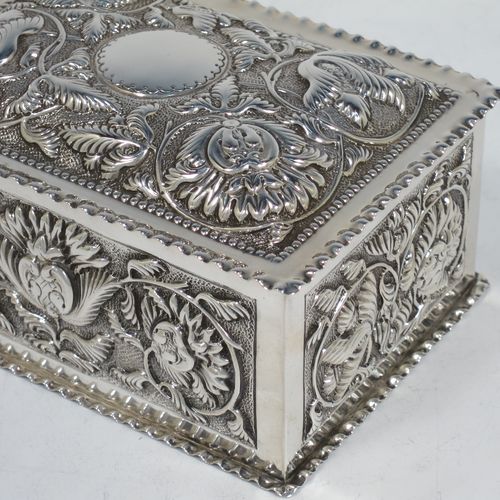 A very pretty Antique Victorian Sterling Silver table box, having a rectangular body with hand-chased floral and scroll decoration, a hinged lid with a vacant cartouche, a gold gilt interior, and sitting on a flat base. Made by Samuel Walton Smith of Birmingham in 1892. The dimensions of this fine hand-made antique silver box are height 6 cms (2.3 inches), length 12 cms (4.75 inches), width 9 cms (3.5 inches), and it weighs approx. 242g (7.8 troy ounces).    