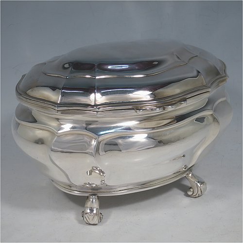 An Antique Edwardian Sterling Silver hand-chased Bonbonnier style heavy table box, having a shaped oval baluster body with a hinged domed lid and thumb-piece, and sitting on four cast scroll feet. Made by David Munsey of London in 1902. The dimensions of this fine hand-made antique silver box are length 20 cms (8 inches), width 14 cms (5.5 inches), height 12.5 cms (5 inches), and it weighs approx. 806g (26 troy ounces).    