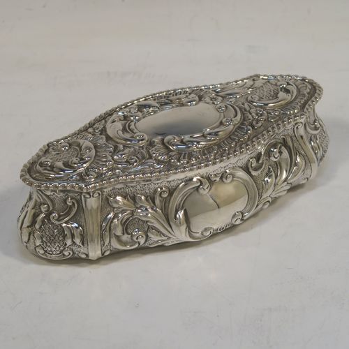 A very pretty Antique Edwardian Sterling Silver Art Nouveau style table box, having a lozenge shaped oval body with a gold-gilt interior hand-chased floral and scroll decoration, a hinged lid with a vacant central oval cartouche, and sitting on a flat base. This beautiful antique silver box was made by John Thompson of Birmingham in 1902. The dimensions of this fine hand-made antique silver Art Nouveau style box are length 13.5 cms (5.25 inches), width 6 cms (2.3 inches), height 4 cms (1.5 inches), and it weighs approx. 88g (2.8 troy ounces).  