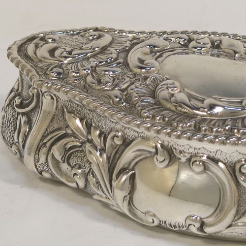 A very pretty Antique Edwardian Sterling Silver Art Nouveau style table box, having a lozenge shaped oval body with a gold-gilt interior hand-chased floral and scroll decoration, a hinged lid with a vacant central oval cartouche, and sitting on a flat base. This beautiful antique silver box was made by John Thompson of Birmingham in 1902. The dimensions of this fine hand-made antique silver Art Nouveau style box are length 13.5 cms (5.25 inches), width 6 cms (2.3 inches), height 4 cms (1.5 inches), and it weighs approx. 88g (2.8 troy ounces).  