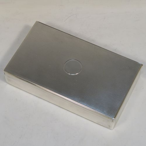 A very elegant Antique Victorian Sterling Silver  table or desk box, having a rectangular body with engine-turned decoration, a vacant round cartouche on the hinged lid, a compartmentalised interior, and all sitting of a flat base. This handsome antique silver box was made by Charles and George Asprey of London in 1896. The dimensions of this fine hand-made antique silver table box are length 18.5 cms (7.25 inches), width 11 cms (4.25 inches), height 3.5 cms (1.3 inches), and it weighs approx. 569g (18.4 troy ounces)  