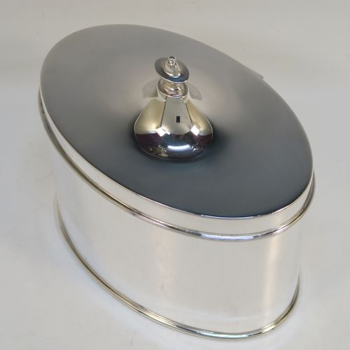 A large and very handsome Antique Edwardian Silver Plated table box, having a very plain oval body with straight sides, a hinged lid with a cast urn-shaped finial, and all sitting on a flat base. This elegant antique table box was made in ca. 1910. The dimensions of this fine hand-made antique silver-plated table box are height 17 cms (6.75 inches), width 17 cms (6.75 inches), and depth 10 cms (4 inches).  