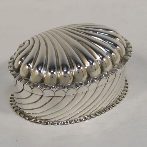 A very pretty Antique Victorian Sterling Silver shell style box, having a shell-shaped oval body with a gold-gilt interior, with hand-chased swirl fluted decoration, a hinged lid, and sitting on a flat base. This beautiful antique silver shell box was made by Horton and Allday of Birmingham in 1888. The dimensions of this fine hand-made antique silver shell style box are length 7.5 cms (3 inches), width 6 cms (2.3 inches), height 4 cms (1.5 inches), and it weighs approx. 57g (1.8 troy ounces).   