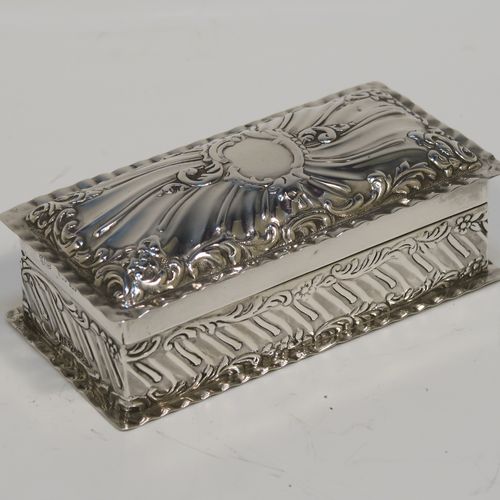 A beautiful Antique Victorian Sterling Silver table box, having a rectangular body with hand-chased floral and scroll and floral decoration, a hinged lid with a vacant central cartouche and matching decoration, and sitting on a flat base. This pretty antique silver box was made by Goldsmiths and Silversmiths of London in 1900. The dimensions of this fine hand-made antique sterling silver box are length 10 cms (4 inches), width 5 cms (2 inches), height 3.5 cms (1.25 inches), and it weighs approx. 97g (3 troy ounces).   