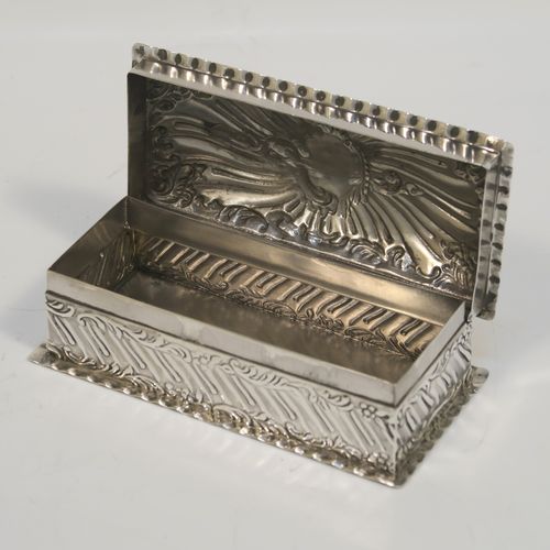 A beautiful Antique Victorian Sterling Silver table box, having a rectangular body with hand-chased floral and scroll and floral decoration, a hinged lid with a vacant central cartouche and matching decoration, and sitting on a flat base. This pretty antique silver box was made by Goldsmiths and Silversmiths of London in 1900. The dimensions of this fine hand-made antique sterling silver box are length 10 cms (4 inches), width 5 cms (2 inches), height 3.5 cms (1.25 inches), and it weighs approx. 97g (3 troy ounces).   