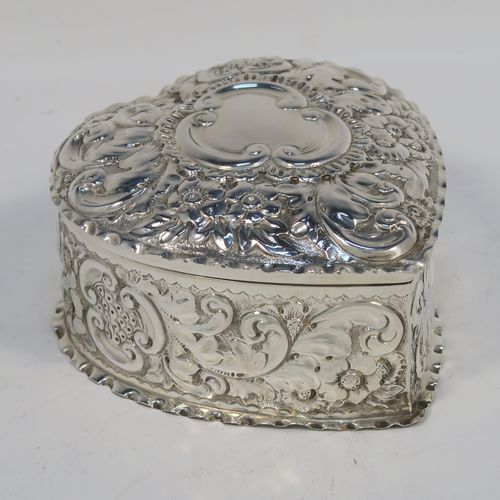 A very pretty Antique Victorian Sterling Silver heart-shaped table box, having a gold-gilt interior, all hand-chased with floral and scroll-work, a hinged lid with vacant cartouche, and all sitting on a flat base. This beautiful silver box was made by Deakin and Francis of Birmingham in 1893. The dimensions of this fine hand-made antique silver hear-shaped box are length 9 cms (3.5 inches), width 8 cms (3.25 inches), height 5 cms (2 inches), and it weighs approx. 96g (3 troy ounces).   